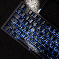 Black mechanical keyboard with blue LED backlighting and white spider web design on keys