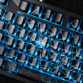 Mechanical keyboard with black keycaps and blue spider web pattern backlighting