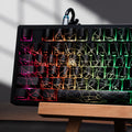 Mechanical keyboard with RGB backlighting and spiderweb pattern on black keycaps, on wooden stand